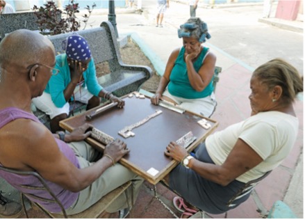 Residents of Matanzas, Cuba, play several rounds of dominoes in a parklet to pass the time. 